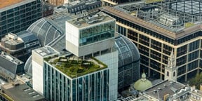 Aerial view of New Court, Rothschild & Co’s London headquarters, showing the modern office complex with glass-fronted buildings, landscaped terraces and courtyards integrated into the surrounding cityscape.