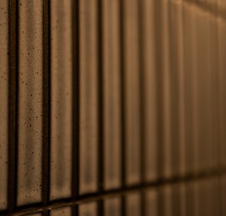 Dark golden finger tile texture from a modern office wall