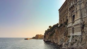 Afternoon light on a classical building on the shoreline, with the modern seafront of Monaco in the distance