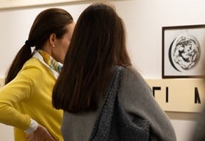 Two clients from the side looking at art on the wall