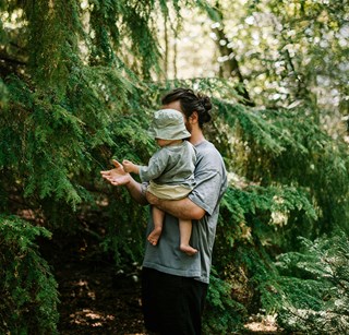 Father holding young child in pine forest