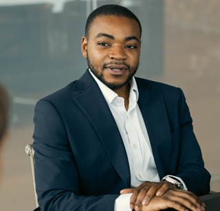 Young professional sat at a table in a modern office meeting room, taken slightly from above