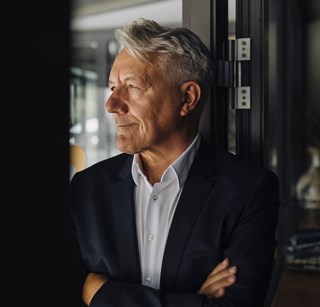 Middle aged man in a suit looking away from camera