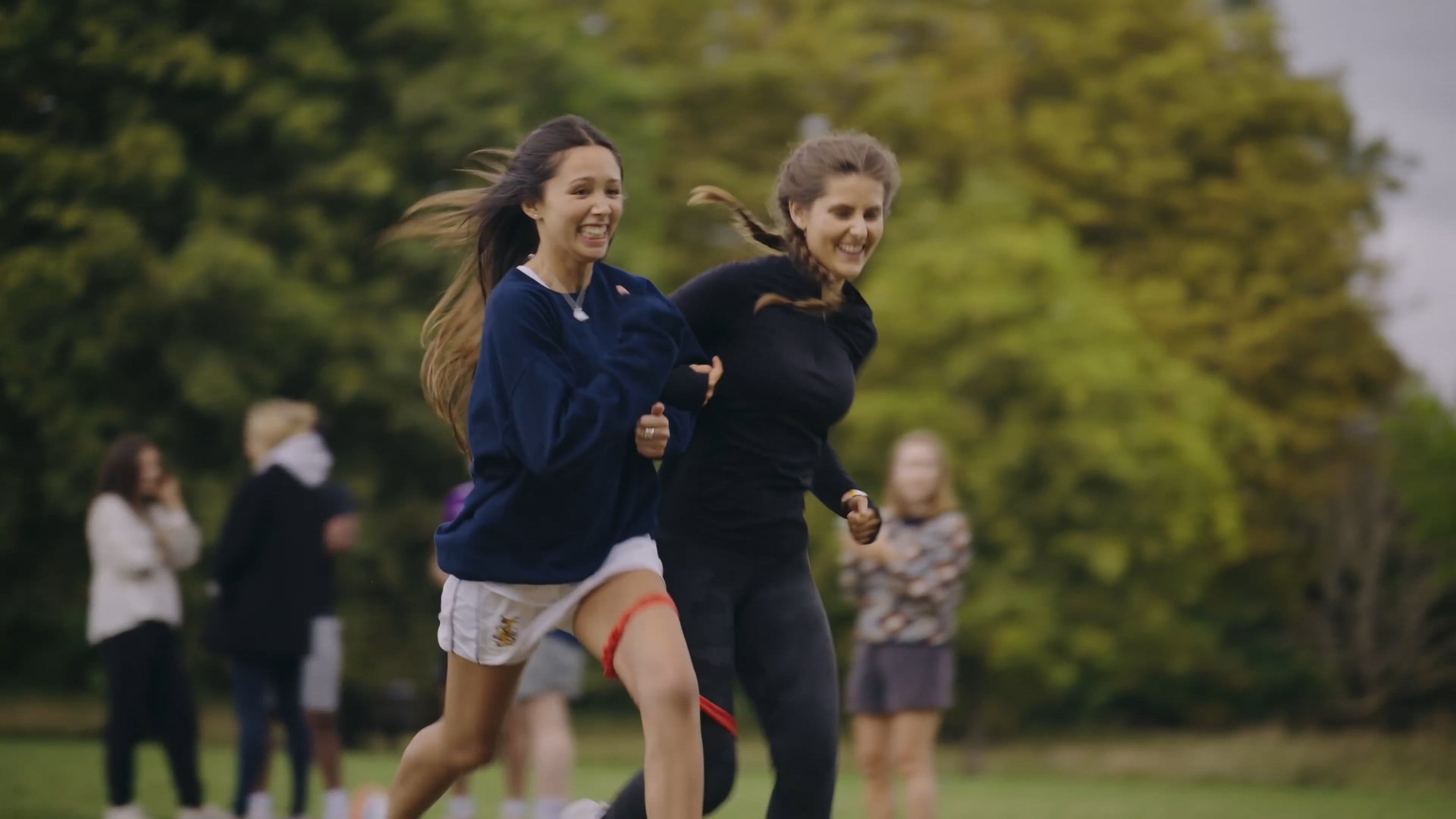 Two women running playing a sport