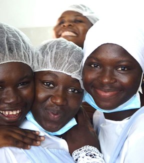 Group of girls from the Ivory Coast smiling during a cooking class