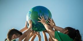 children holding up a miniature globe