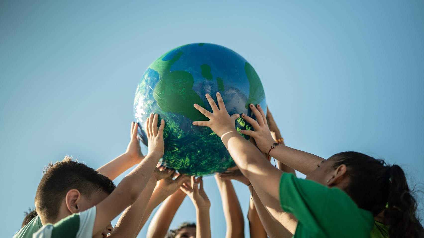 children holding up a miniature globe