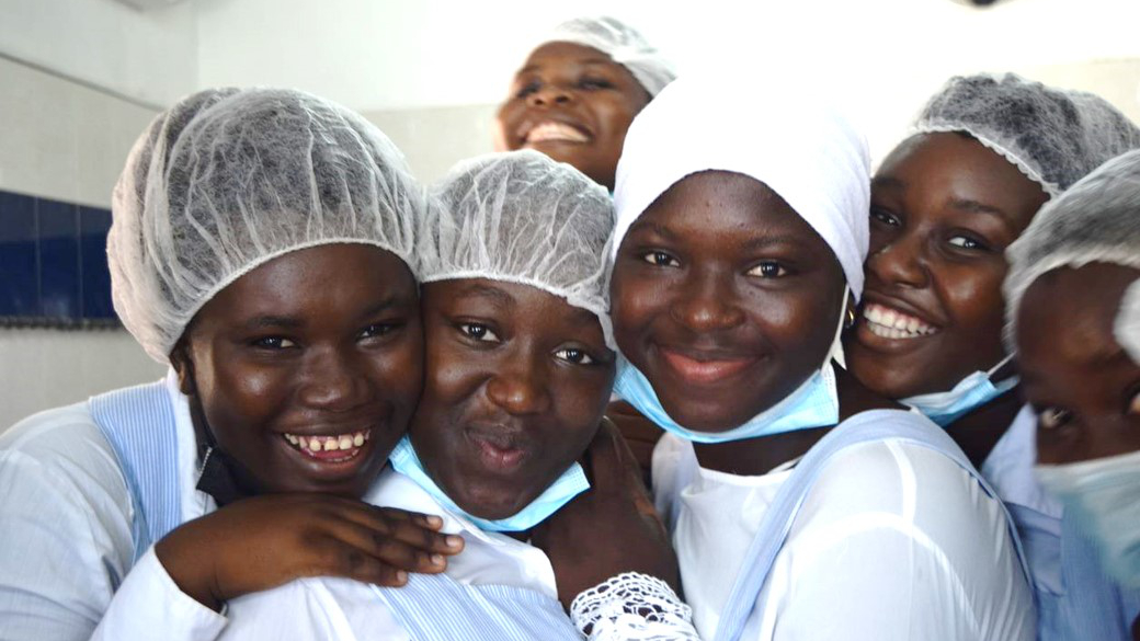 Group of girls from the Ivory Coast smiling during a cooking class