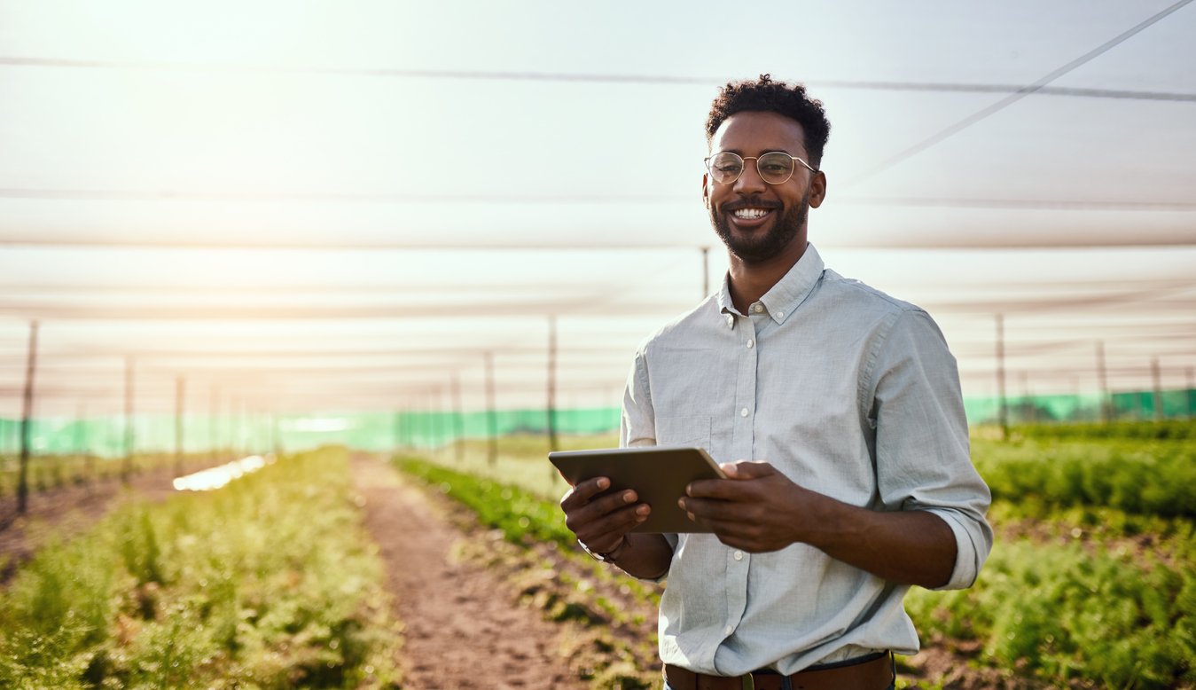 man in glasses holding clipboard in agricultural field