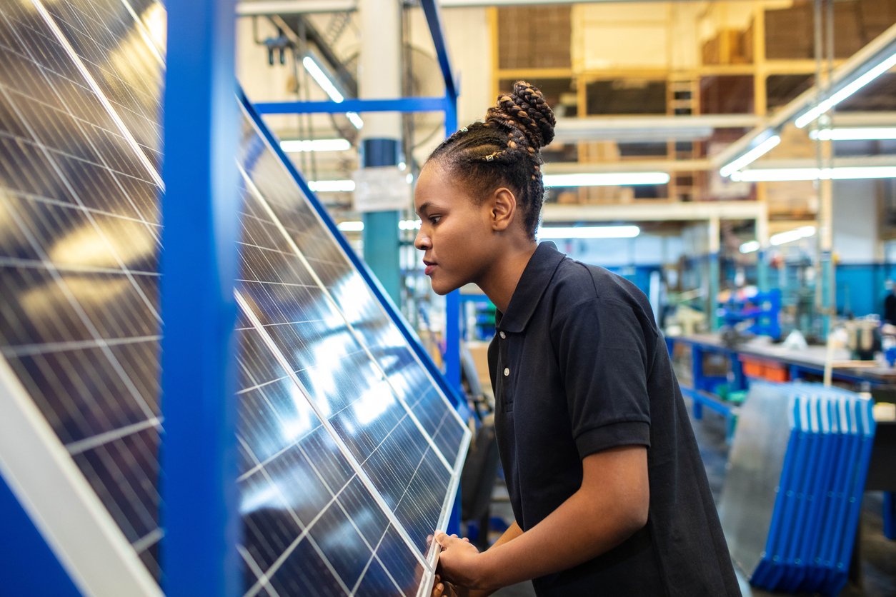 woman inspecting solar panel