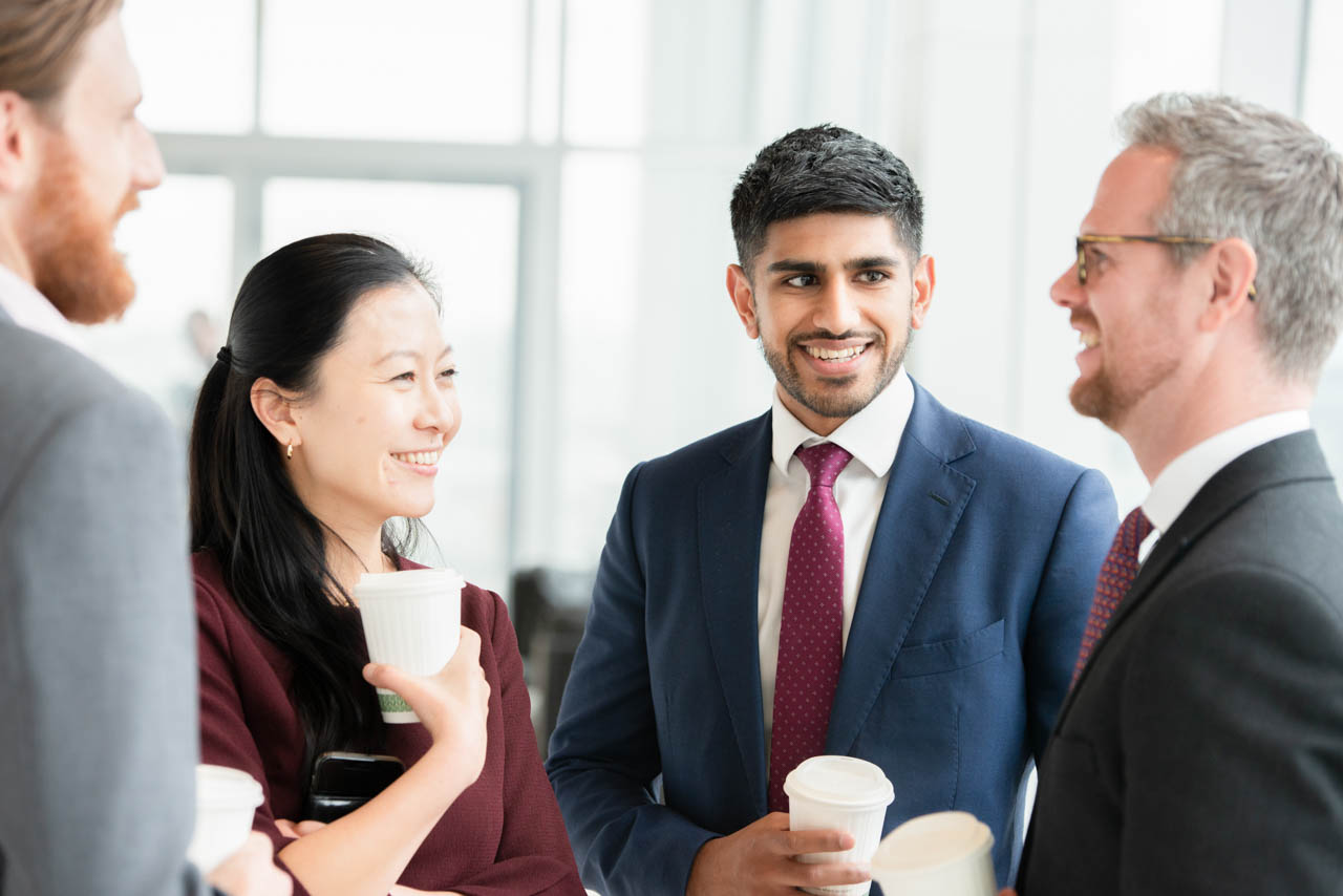 Three colleagues conversing while enjoying coffee