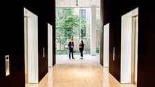 Two people having a discussion by the lobby lifts