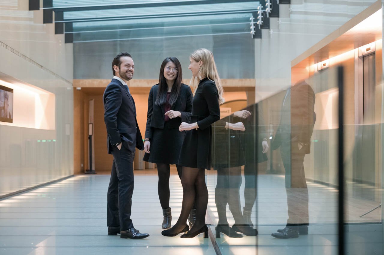 Three people having a discussion in a hallway