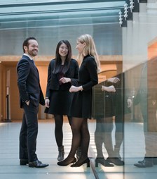Three people having a discussion in a hallway