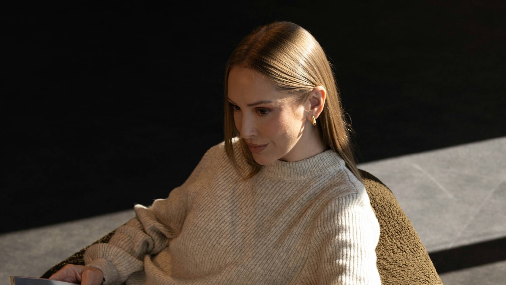 Woman sitting in a chair reading a magazine