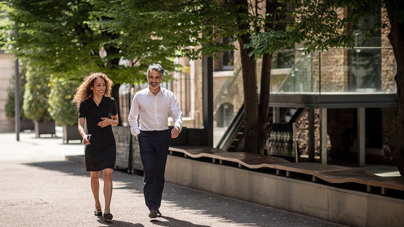 Two people walking down the street in the city of London