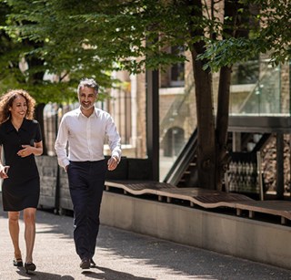 Two people walking down the street in the city of London