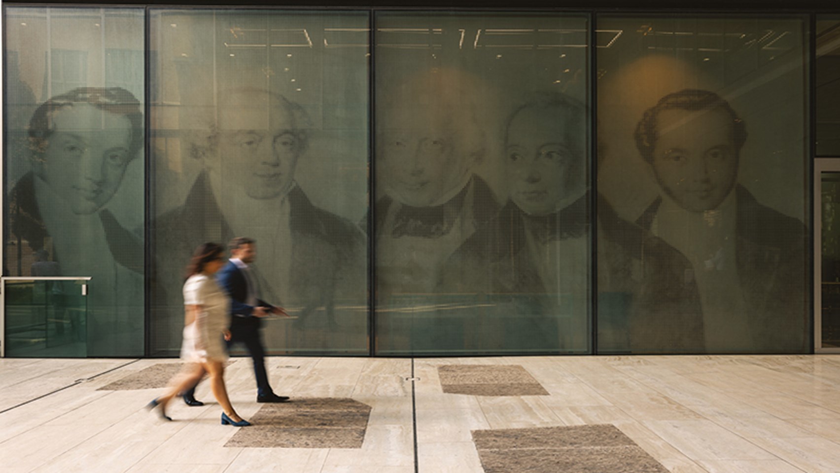 2 individuals walking outside of the Rothschild & Co, New Court offices.