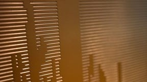 Abstract close-up of perforated metal panel illuminated with warm ambient lighting