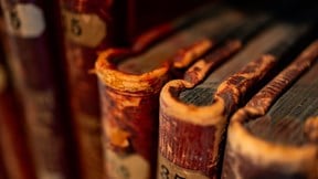 Zoomed in image of some old books next to each other in a book case