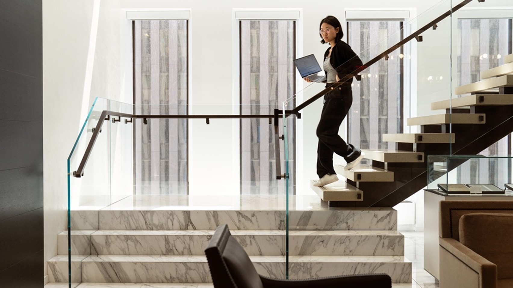 Image of a lady walking down some stairs inside the Rothschild offices