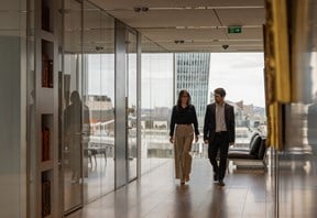 A pair of pair deep in conversation walking down a corridor at the Rothschild & Co New Court office
