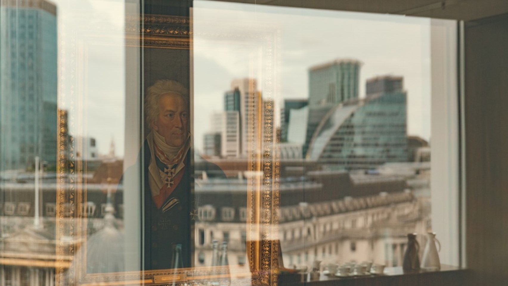 Image of a Rothschild family painting with a reflection behind it of the City of London skyline