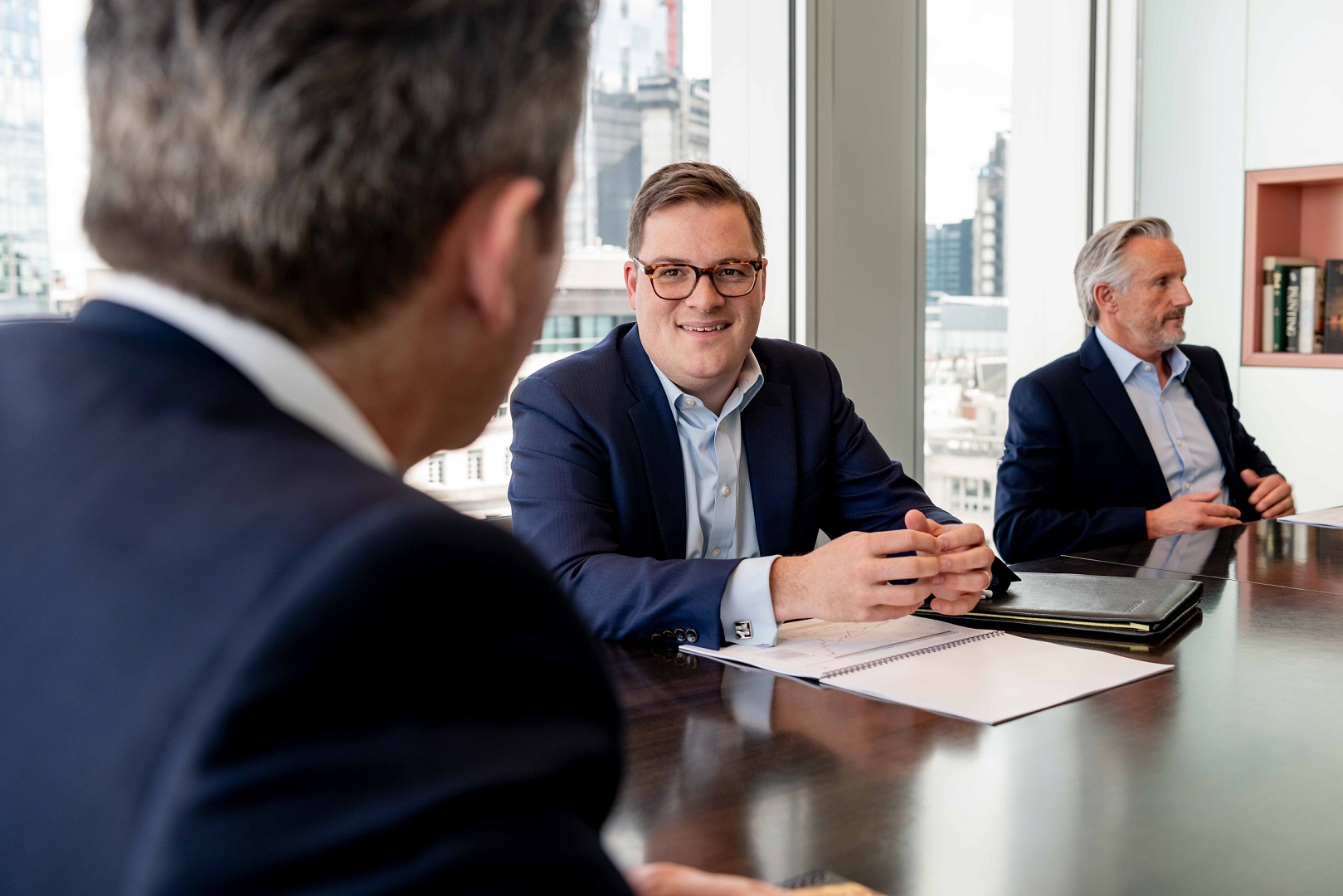 Man talking smiling and talking to clients during a meeting