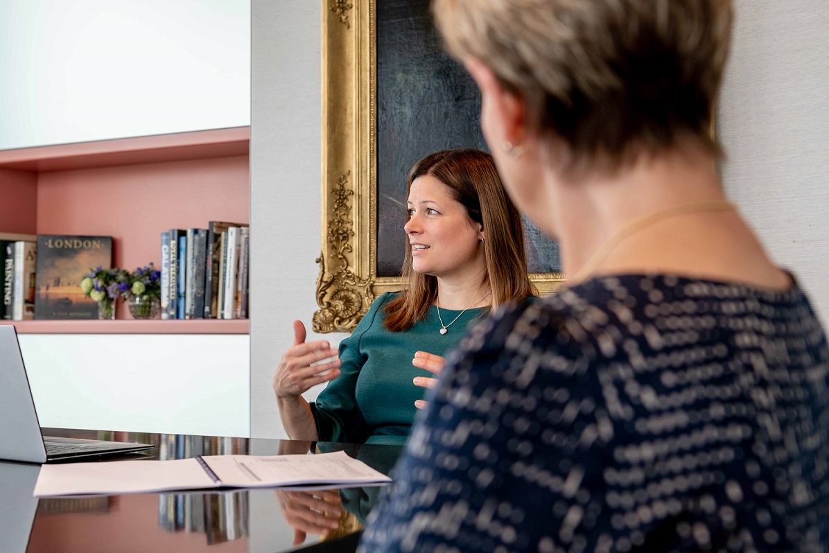 Lady explaining something to clients during a meeting