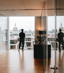 Man overlooking city skyline with his reflection in glass