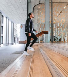 Man walking up the stairs of Rothschild & Co New Court office