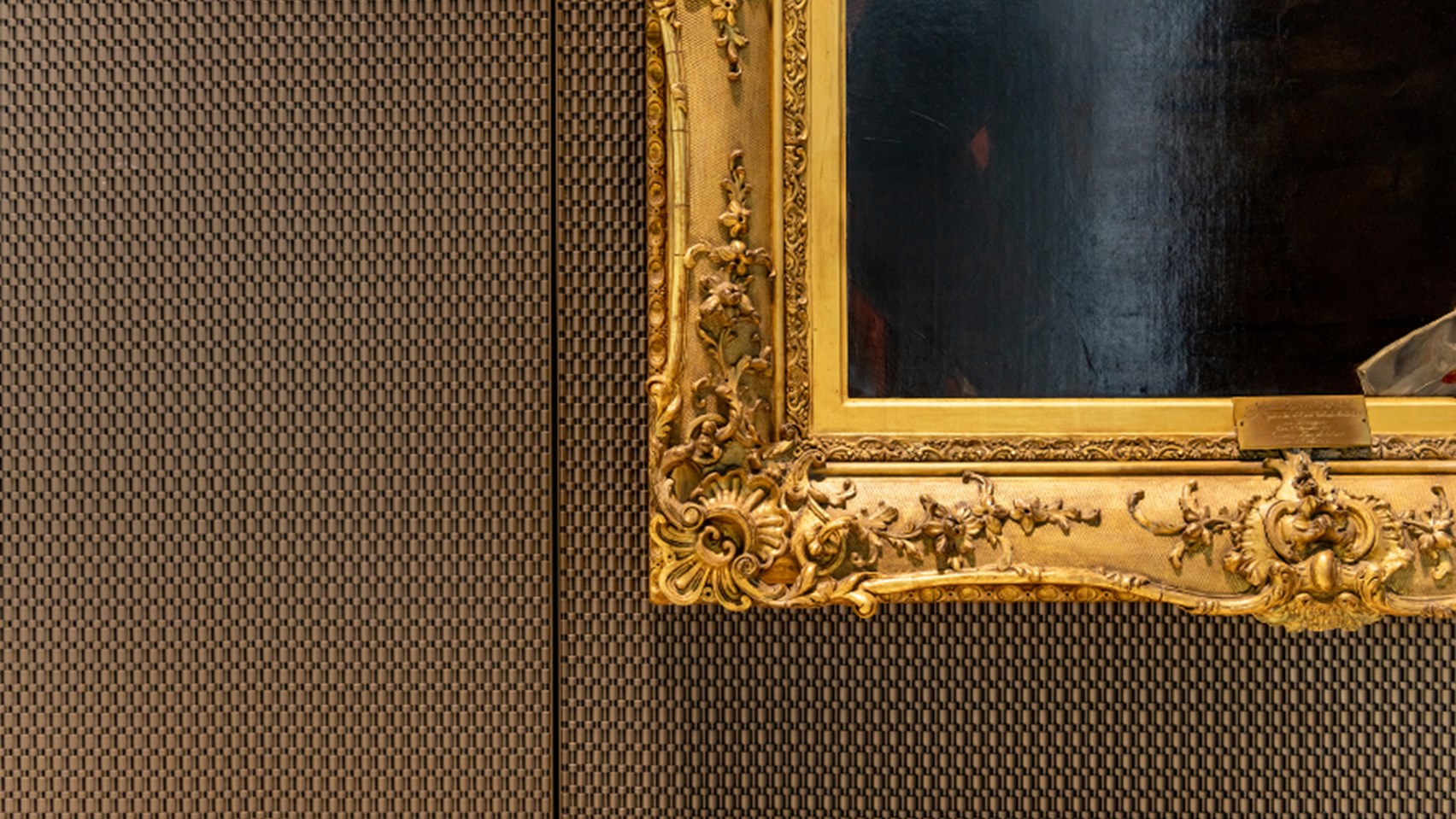 Photo of a dark oil painting with bright gold frame