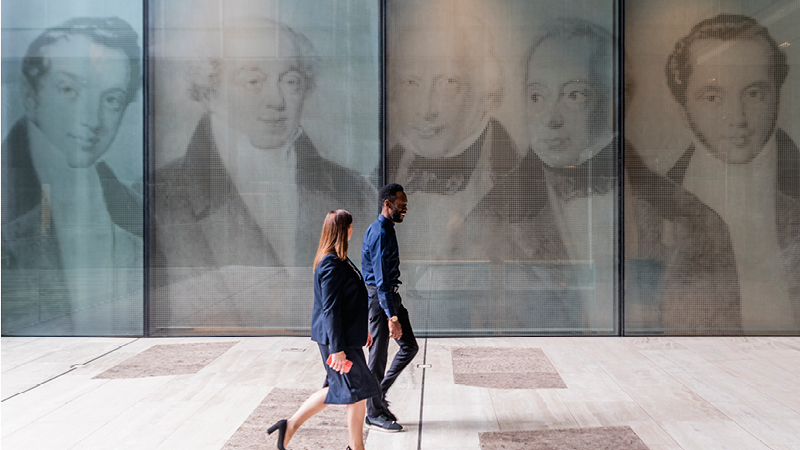 2 employees walking outside the New Court reception