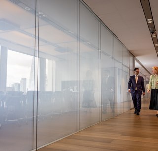 Image of two people having a conversation as they walk through the London Rothschild office