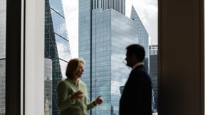 Two people having a conversation in one of the window of Rothschild & Co's New Court London office