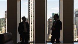 Image of two people having a conversation in a meeting room window in the Rothschild USA office