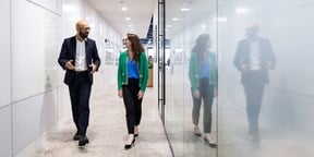 Male and female colleague walking in the offices of Rothschild & Co Redburn