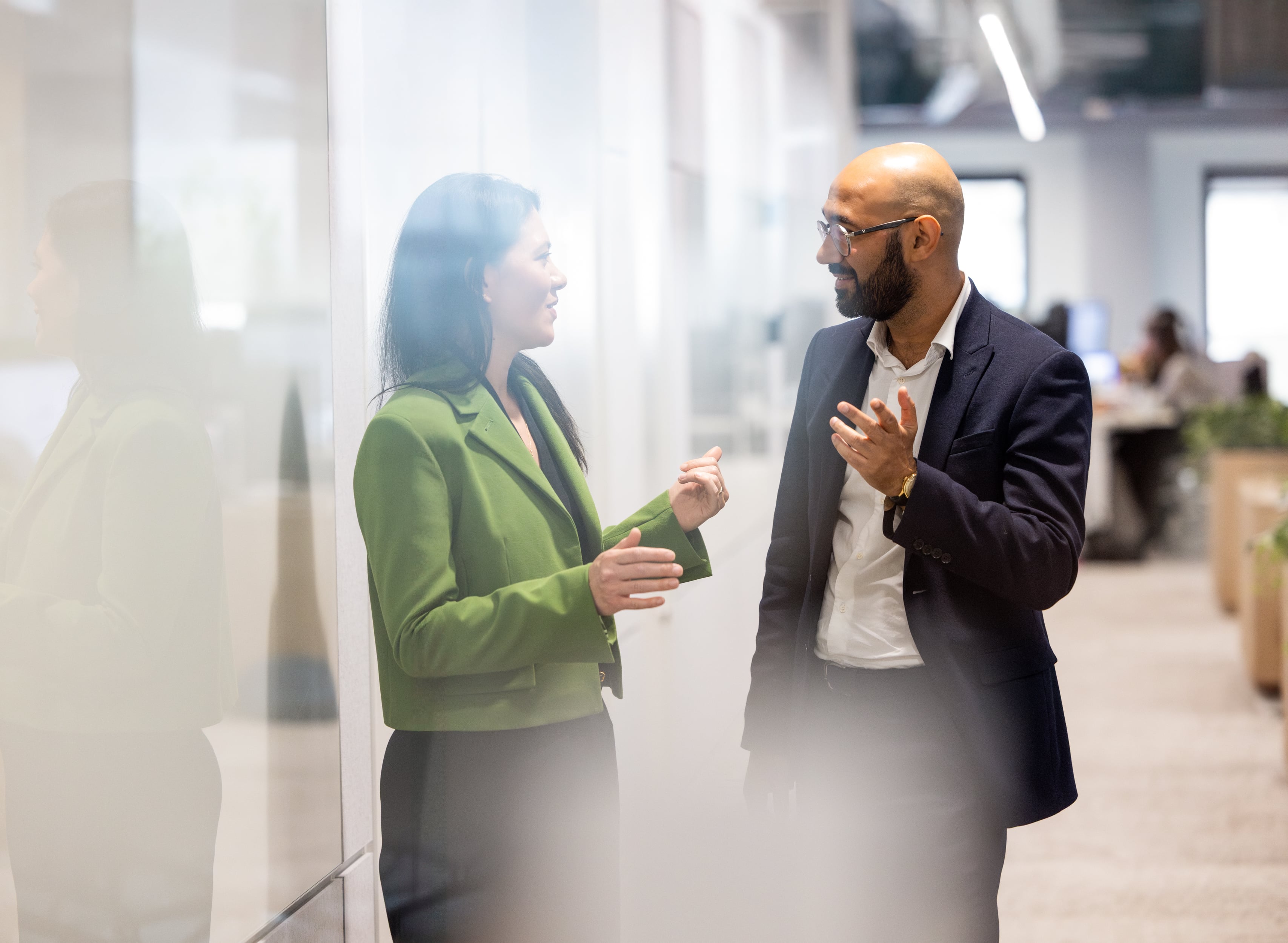 Male and female colleague walking in the offices of Rothschild & Co Redburn