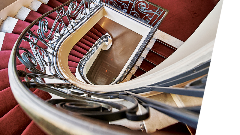 Birds-eye view image of winding stairs with red carpet